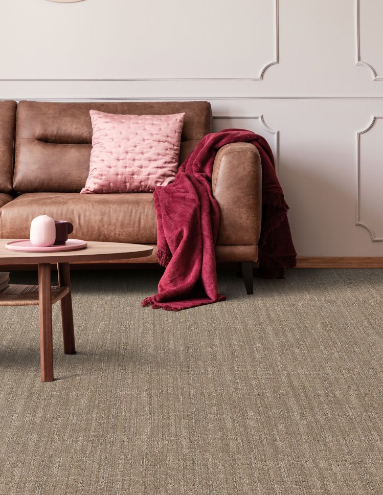 brown textured carpets in a stylish living room with brown leather couch and pink accent wall