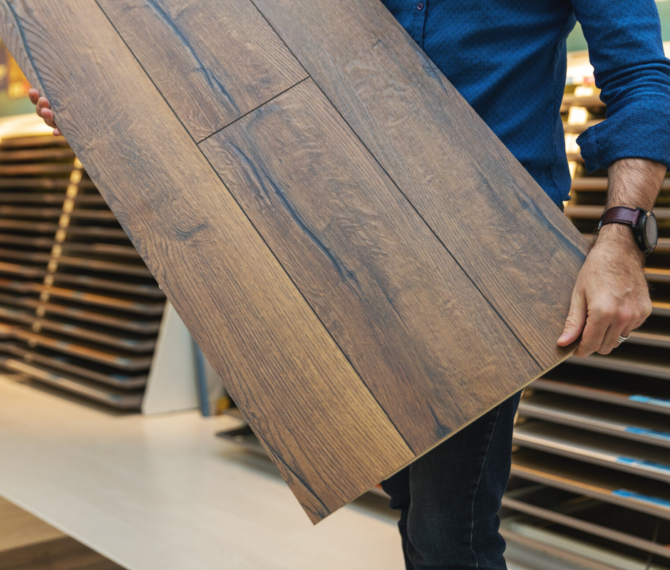 Person holding large laminate flooring sample